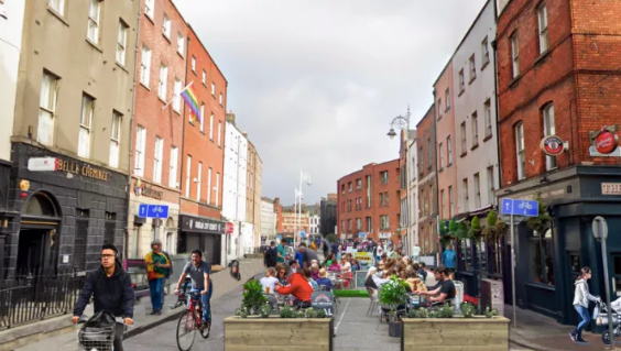 shot of Capel Street with people dining outside and cycling
