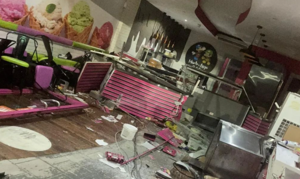 Interior of a gelato shop with smashed glass, furniture in disarray and other evidence of an accident