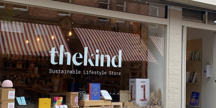 Shop Front with "The Kind - Sustainable Lifestyle Store" written on the window - books, candles and sustainable products on display