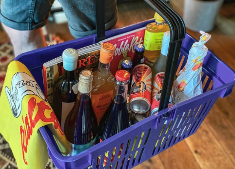 a shopping basket neatly packed with wine, craft beer cans and cocktail bottles