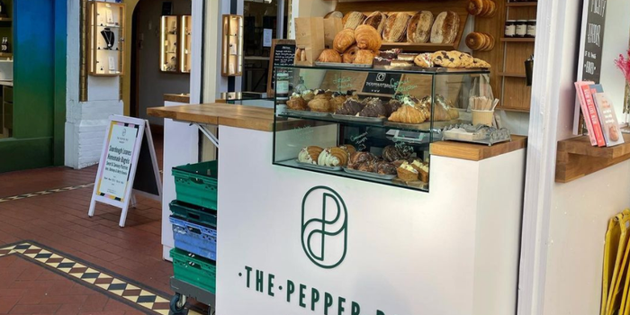 pepper pot bakery stall in georges street arcade, a cream coloured stall with green signage, shelves stacked with pastries and breads