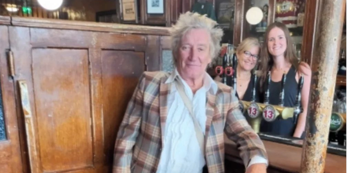 Rod Stewart posing for a photo at the bar in Gravediggers pub