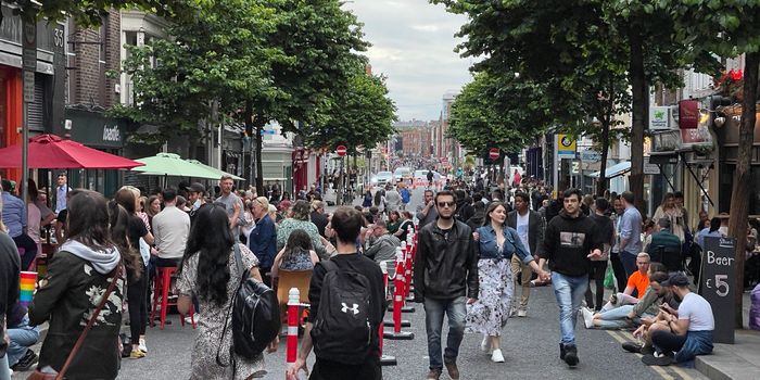 traffic-free parliament street in dublin with people walking around and sitting outside bars