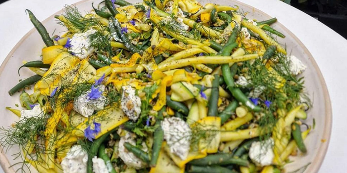 summer style salad on a plate with green beans, yogurt dressing and dill