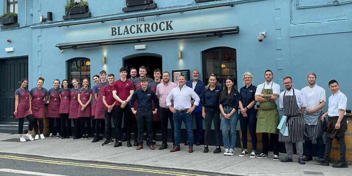 large group of waiters, bar staff and chefs standing outside a pub in Blackrock