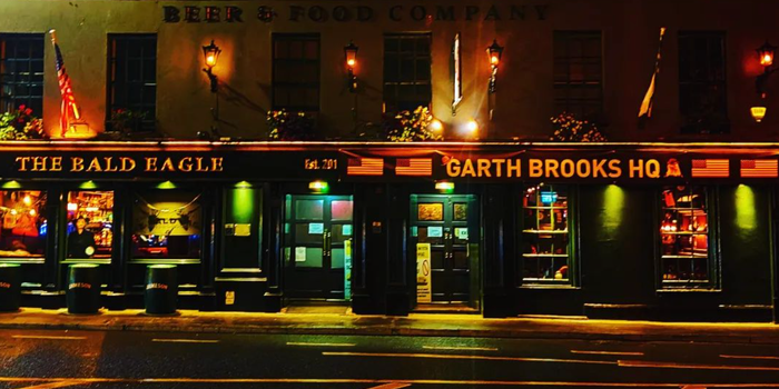 exterior of a pub at nighttime with a sign that reads "garth brooks hq"