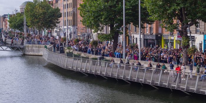 a protest in Dublin with thousands of people marching along the liffey