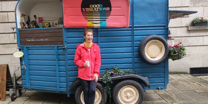 woman in a pink coat standing outside a horsebox cafe