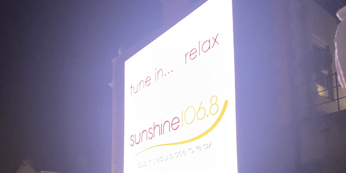 glowing billboard displaying the logo for radio station Sunshine 106.8fm