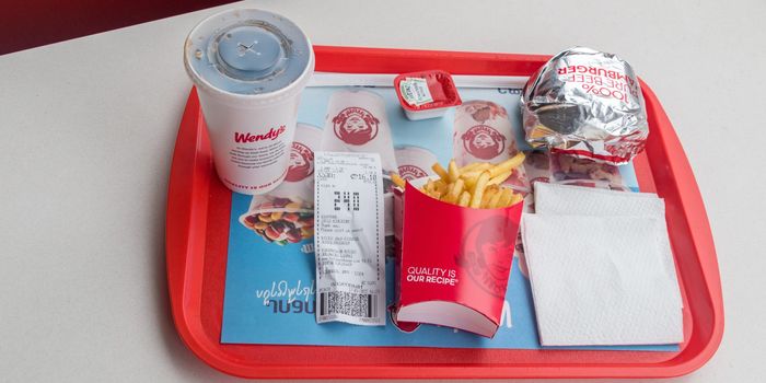 fast food tray from Wendy's with burger, fries, fountain drink, napkins and a receipt