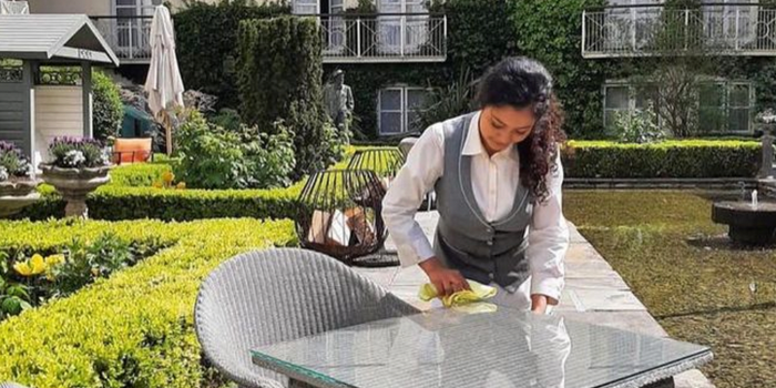 staff member at the merrion wiping an outdoor table