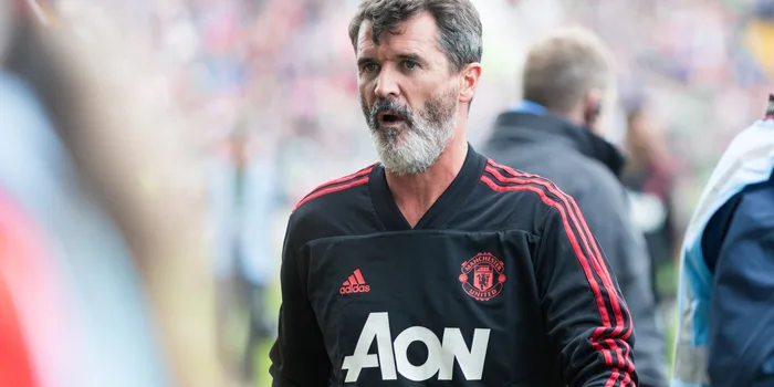 Roy Keane in a Man United training top at the sideline of a match